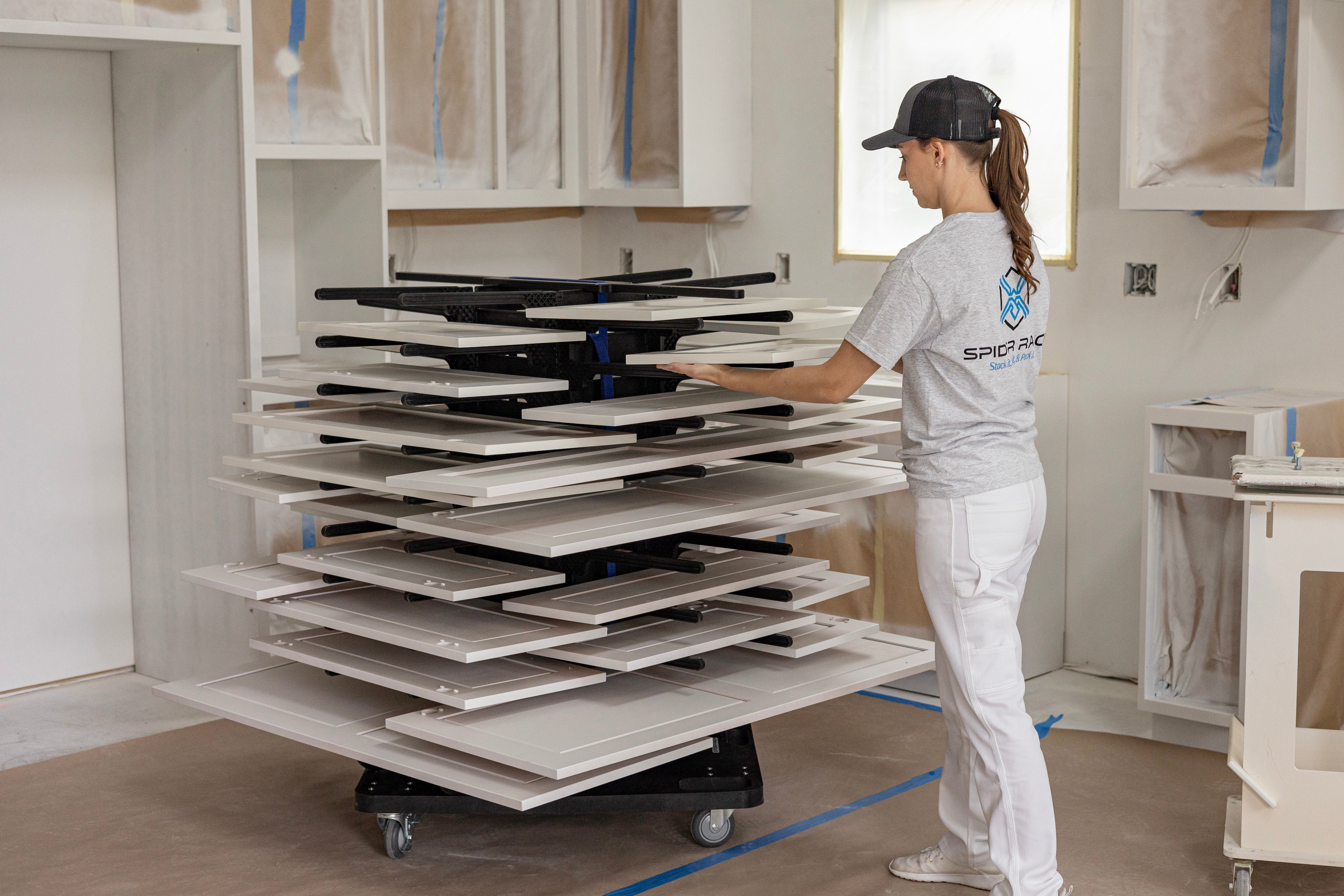 Person using Spider Racks portable cabinet door paint drying rack. 